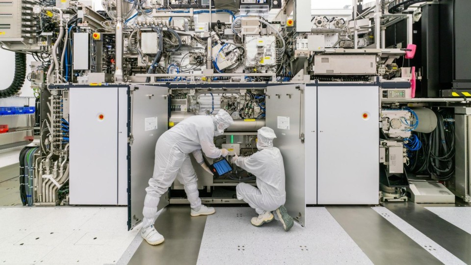 ASML-chipproductiemachine, met twee medewerkers